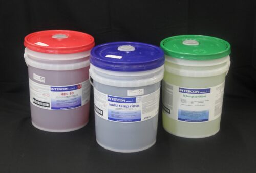 photo of three 5-gallon buckets, one with a red lid, one with a blue lid and one with a green lid, of cleaning agents sold by C&C Suppliers against a black background