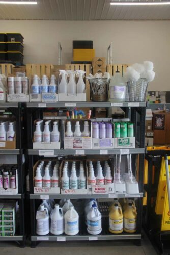 Four shelves filled with bathroom cleaners and cleaning brushes at C & C Suppliers