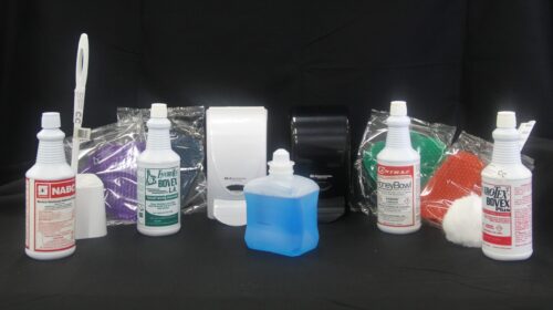 photo of an assortment of bathroom cleaning agents and tools sold by C&C Suppliers arranged against a black background