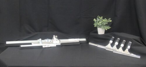 photo of several squeegees sold by C&C Suppliers of various sizes staged with a green plant against a black background