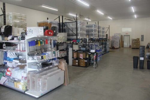 photo of the left side of the C&C Suppliers warehouse showing several aisles of shelves full of products